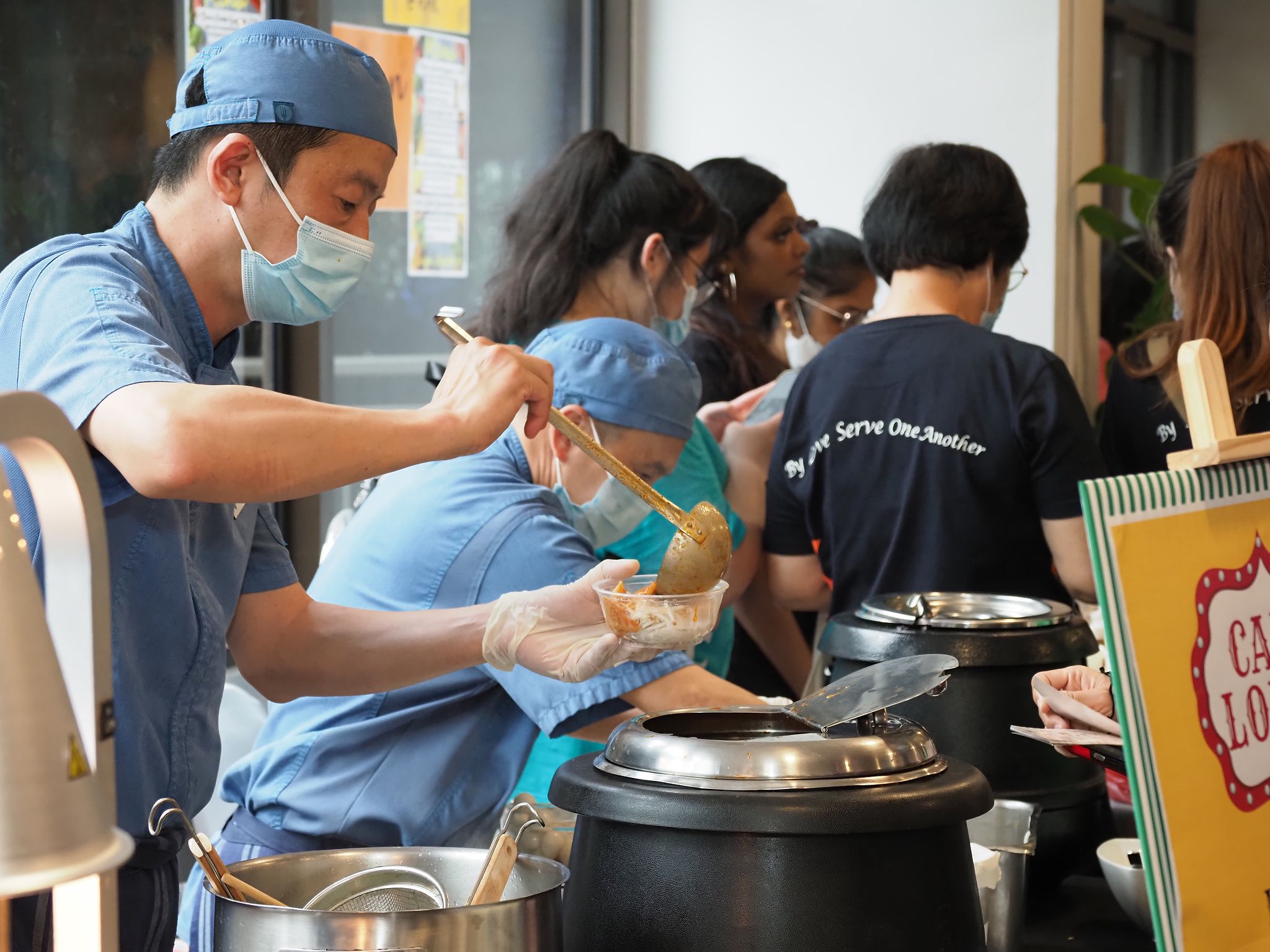 YWCA’s Fort Canning kitchen staff serving Laksa with Abalone